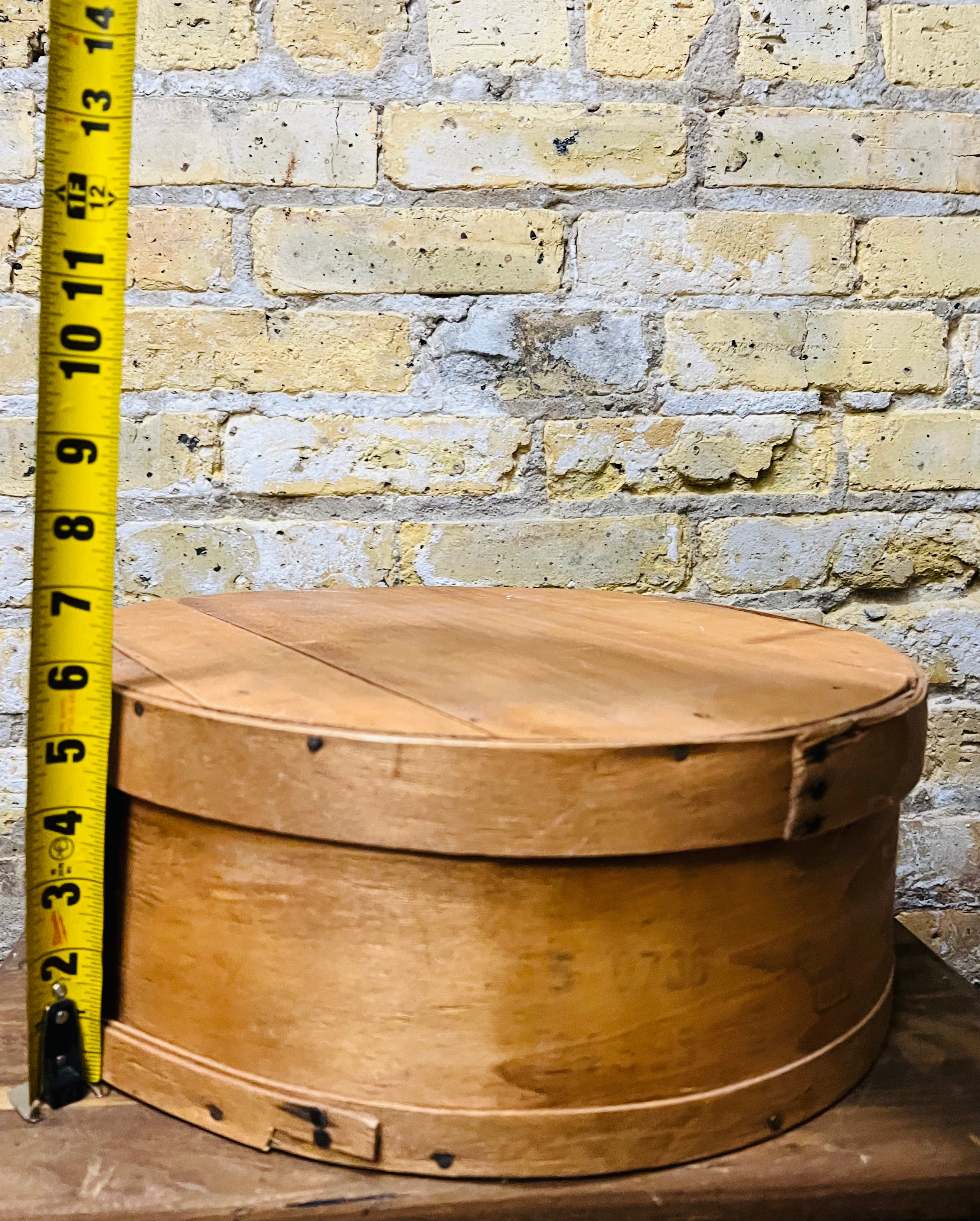 Vintage wooden cheese wheel storage box.