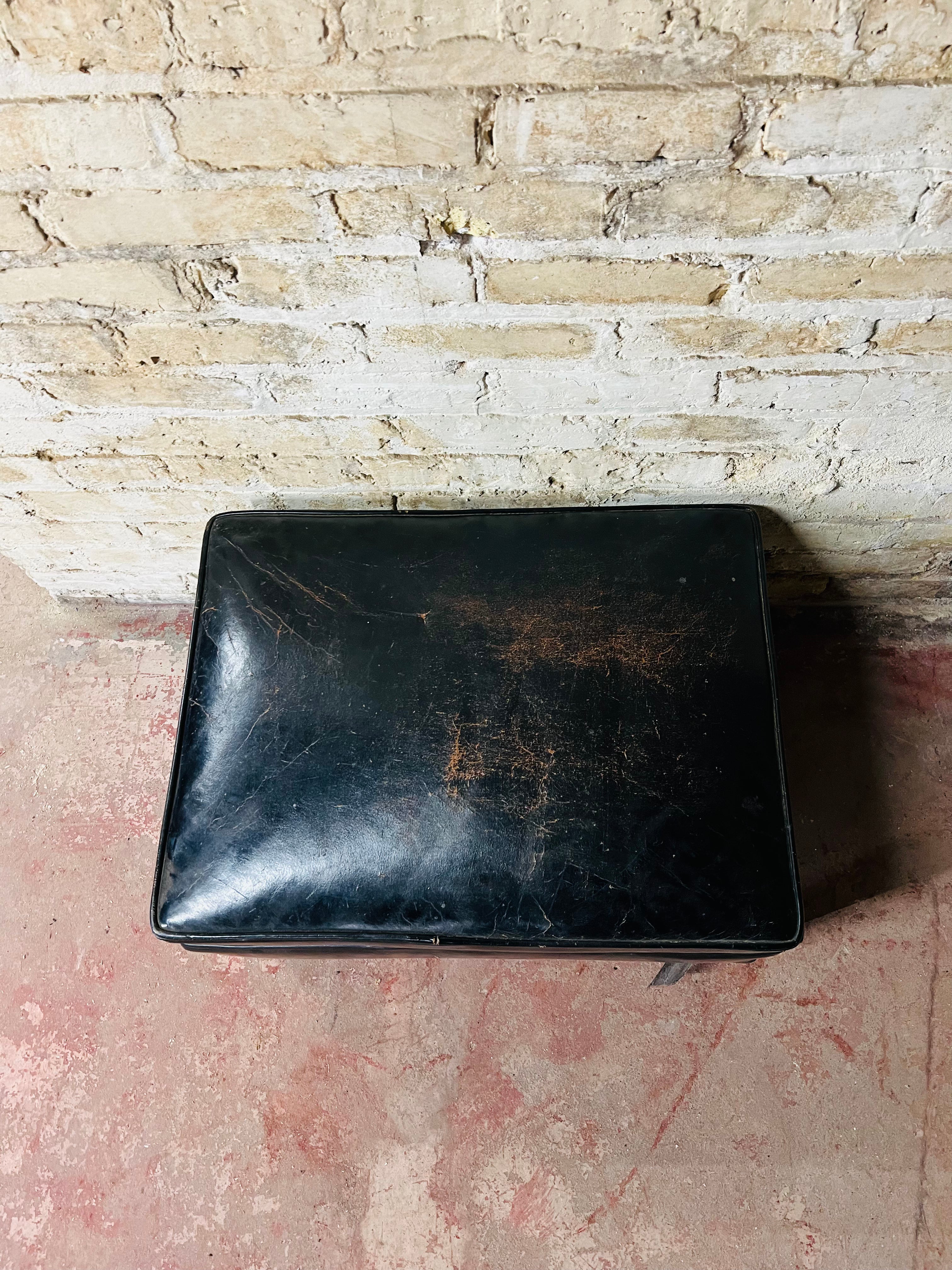 Vintage leather ottoman on wheels.