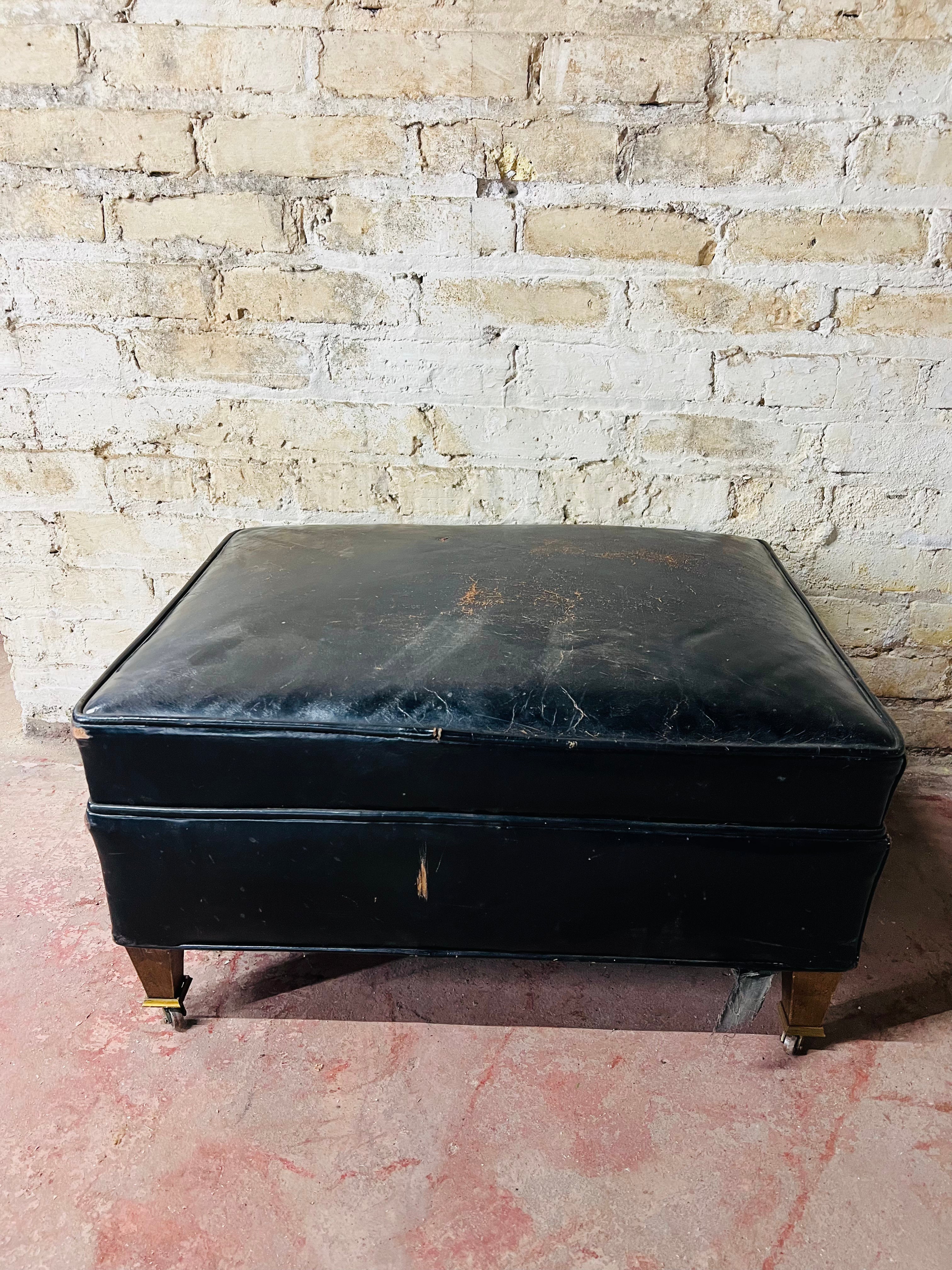 Vintage leather ottoman on wheels.