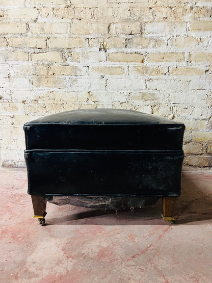 Vintage leather ottoman on wheels.