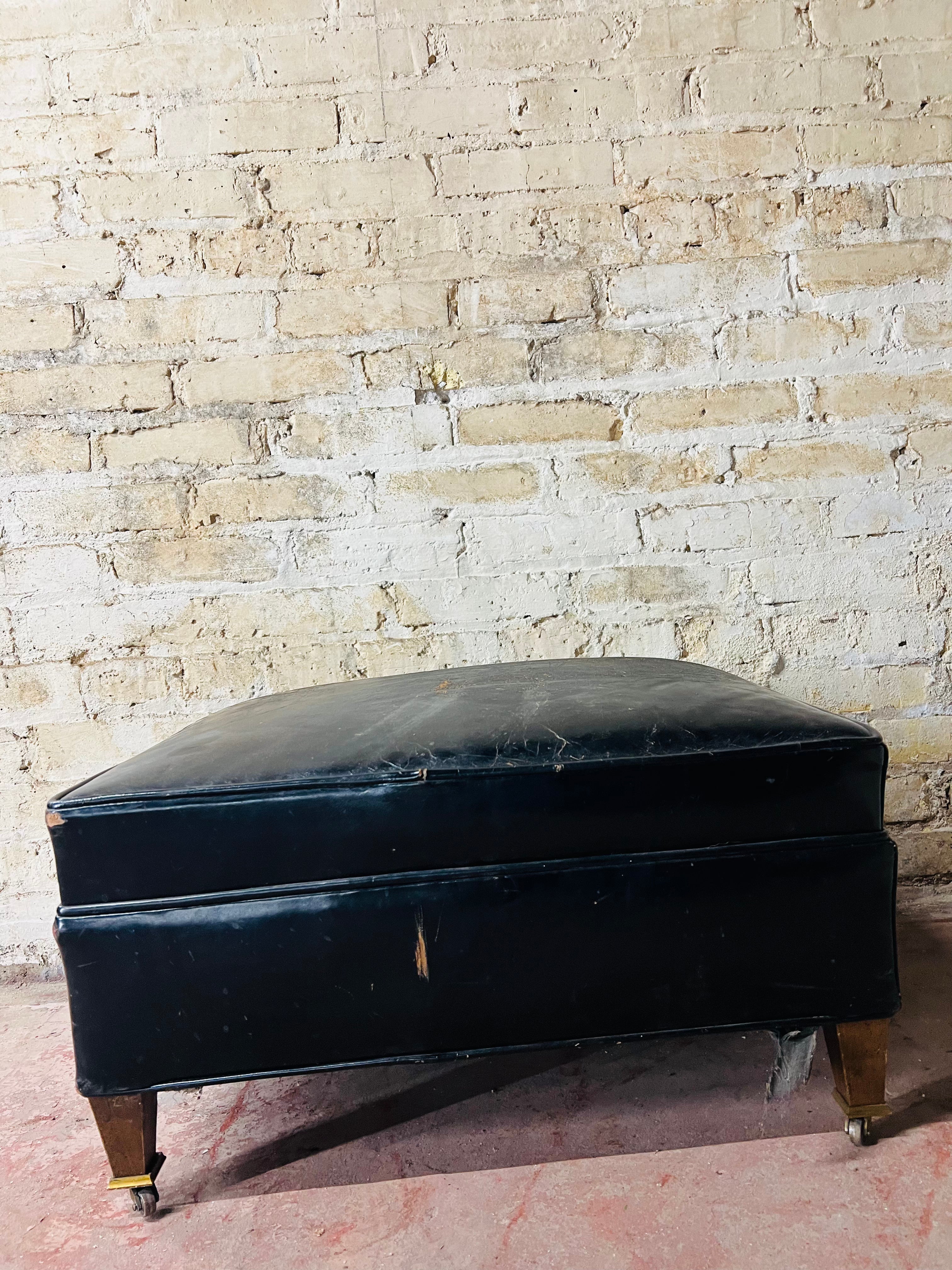 Vintage leather ottoman on wheels.