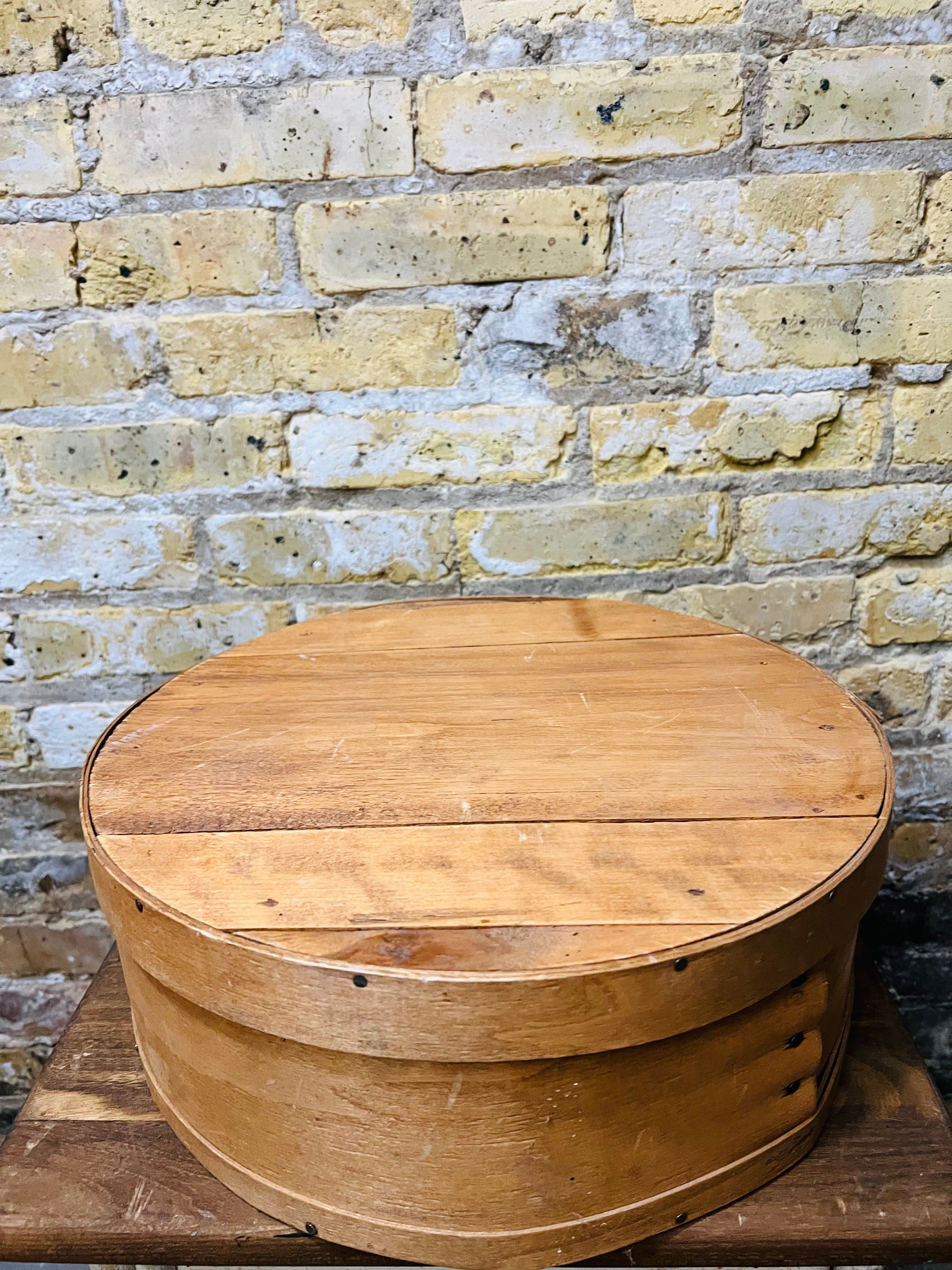 Vintage wooden cheese wheel storage box.