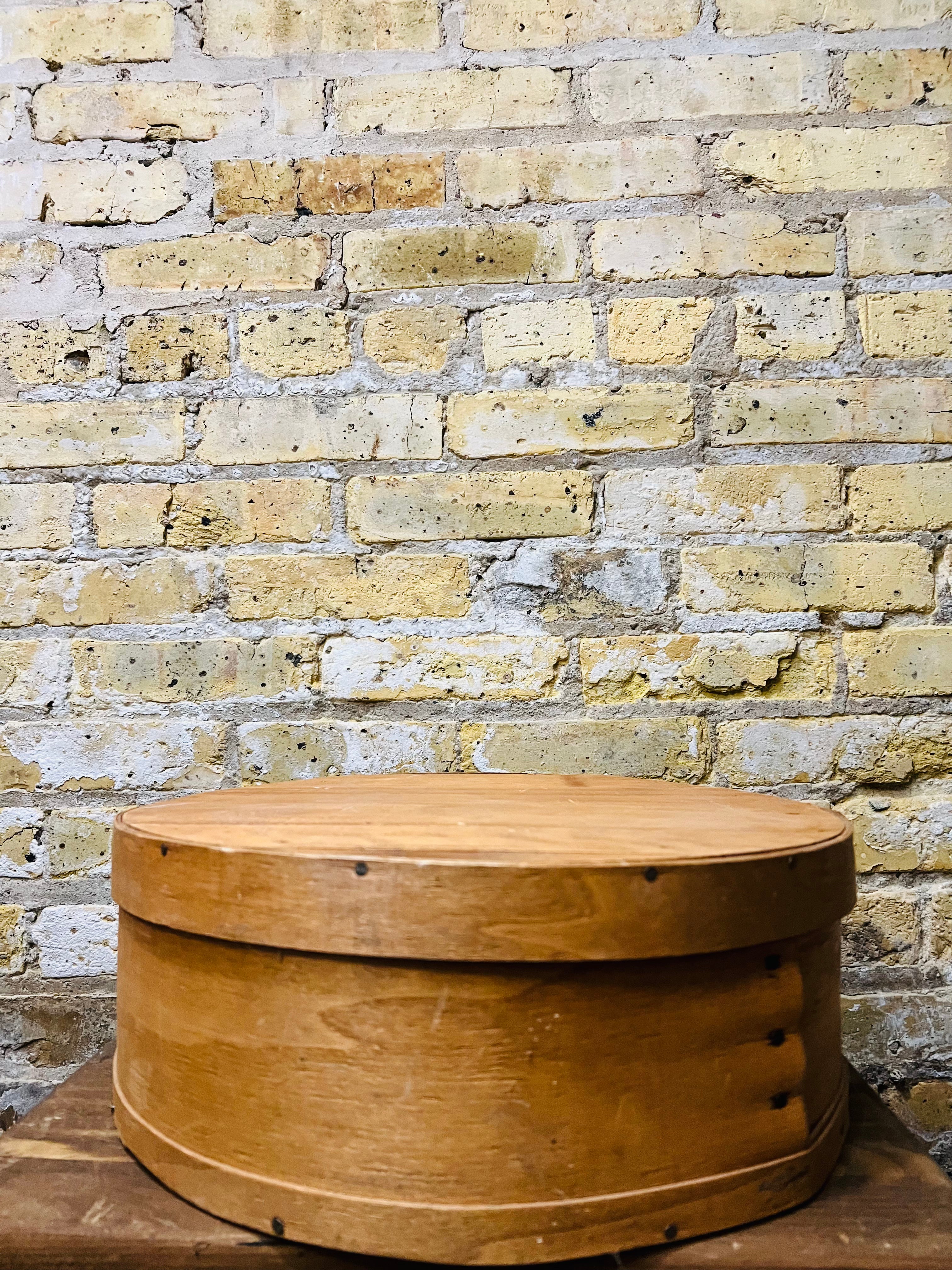 Vintage wooden cheese wheel storage box.