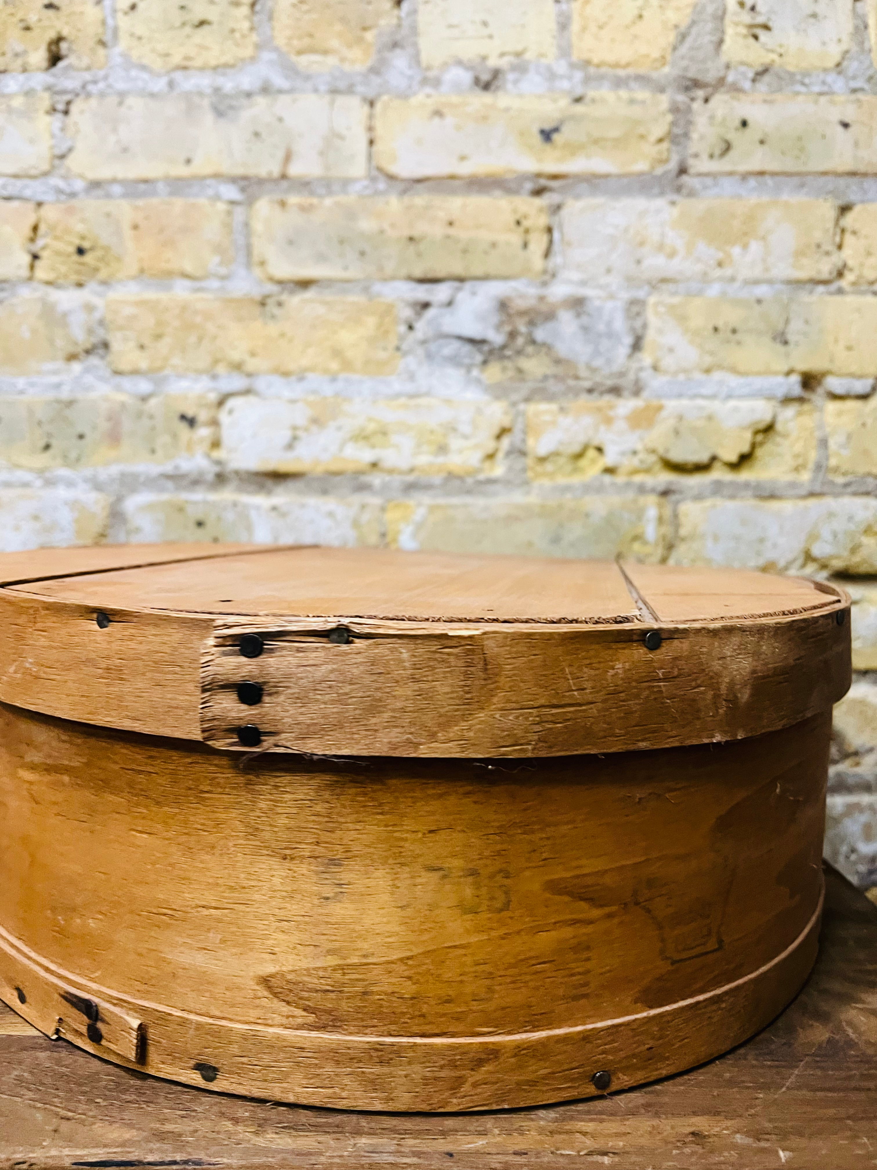 Vintage wooden cheese wheel storage box.