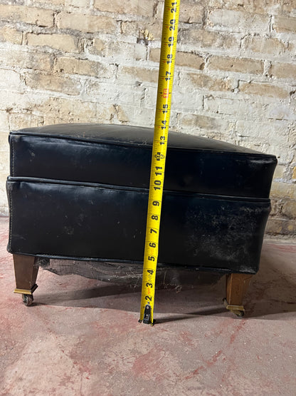 Vintage leather ottoman on wheels.